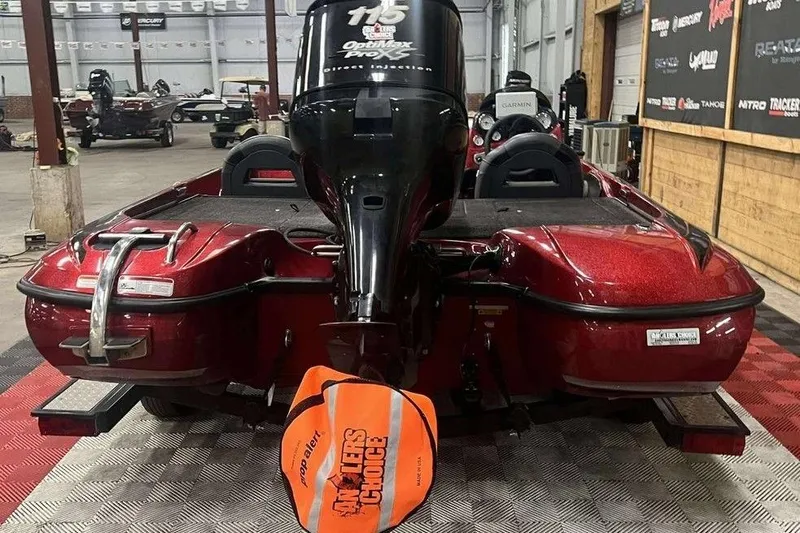 Slide: The Image of Red 2011 Nitro Z6 boat with outboard motor in a garage setting. - 3