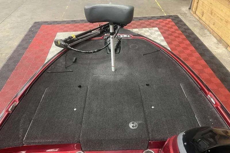 Slide: The Image of 2011 Nitro Z6 boat deck with trolling motor and padded seat on checkered mat. - 8