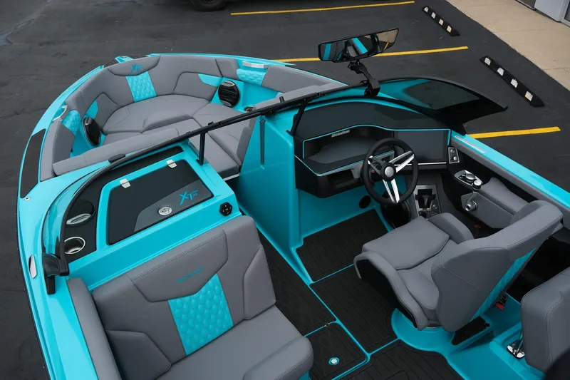 Slide: The Image of 2026 MasterCraft XT23 boat interior with turquoise and gray seating, modern dashboard, and steering wheel. - 16