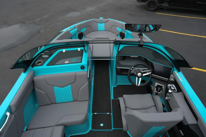 Slide: The Image of 2026 MasterCraft XT23 boat interior with turquoise and gray seating, modern dashboard, and steering wheel. - 17