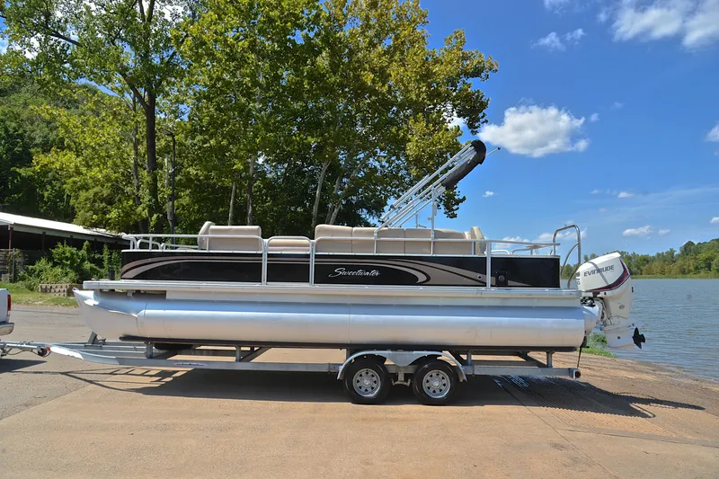 Slide: The Image of 2014 Godfrey SWEETWATER 2486 pontoon boat on trailer by a lake. - 10