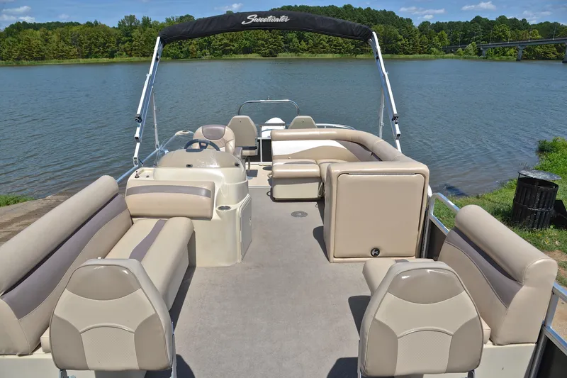 Slide: The Image of 2014 Godfrey SWEETWATER 2486 pontoon boat with spacious seating on a serene lake. - 19