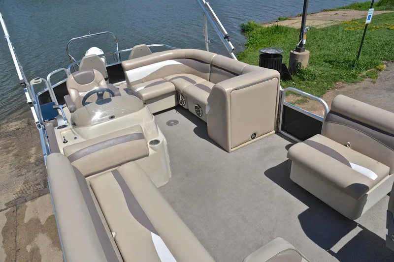 Slide: The Image of 2014 Godfrey SWEETWATER 2486 pontoon boat with beige seating, docked by the water. - 22
