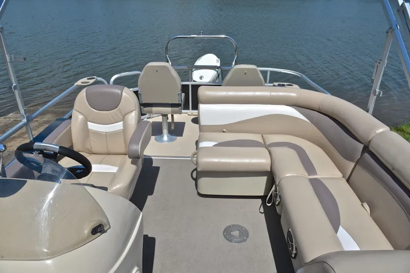 Slide: The Image of 2014 Godfrey SWEETWATER 2486 pontoon boat interior with beige seating and steering wheel. - 23