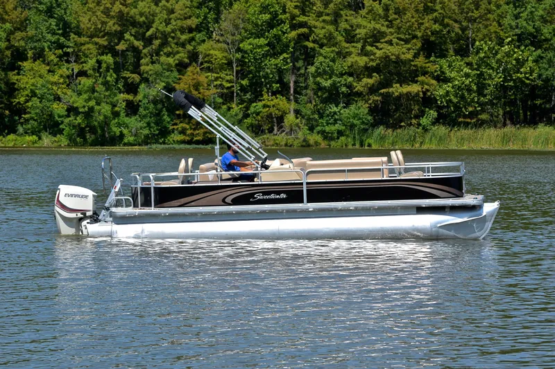Slide: The Image of 2014 Godfrey SWEETWATER 2486 pontoon boat on a serene lake with lush green trees. - 6