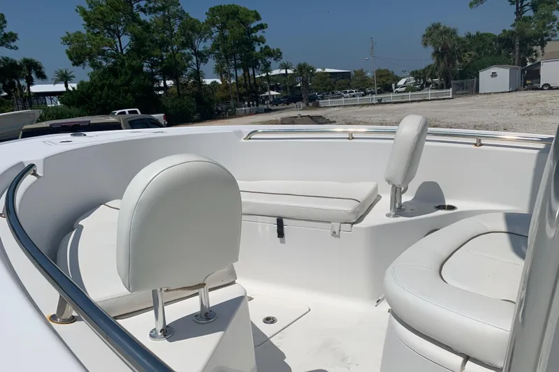 Slide: The Image of 2015 Sportsman Open 212 Center Console boat interior with white seating and clear sky. - 10