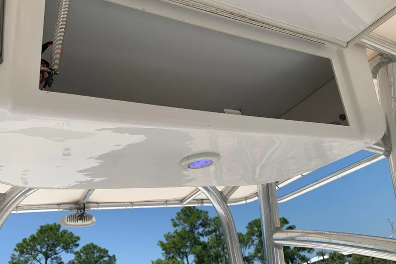 Slide: The Image of 2015 Sportsman Open 212 Center Console storage compartment with blue LED light, outdoor setting. - 18