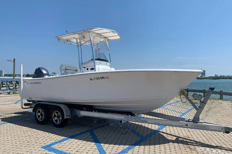 Slide: The Image of 2015 Sportsman Open 212 Center Console boat on trailer by waterfront. - 2