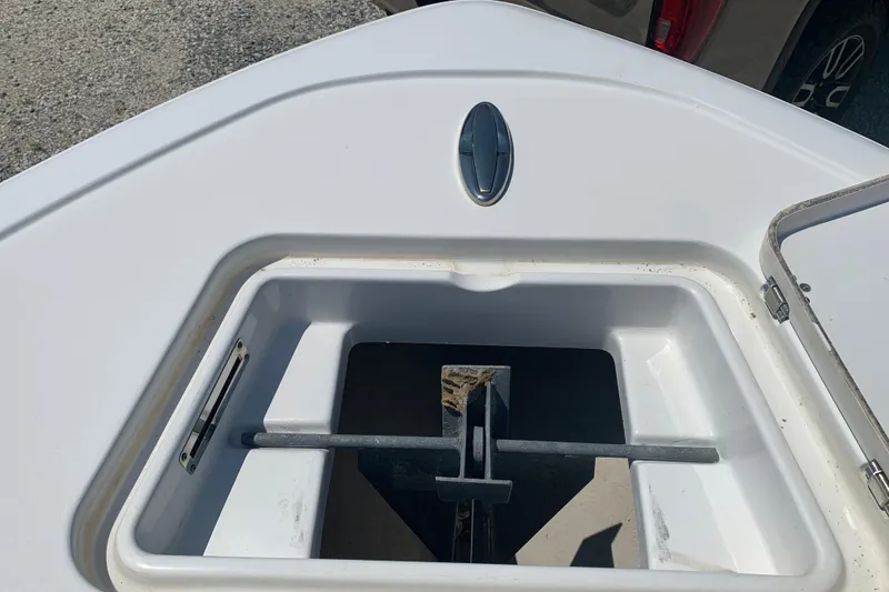 Slide: The Image of 2015 Sportsman Open 212 Center Console anchor compartment, open lid, white interior. - 21