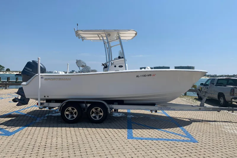 Slide: The Image of 2015 Sportsman Open 212 Center Console boat on trailer, parked near waterfront. - 3