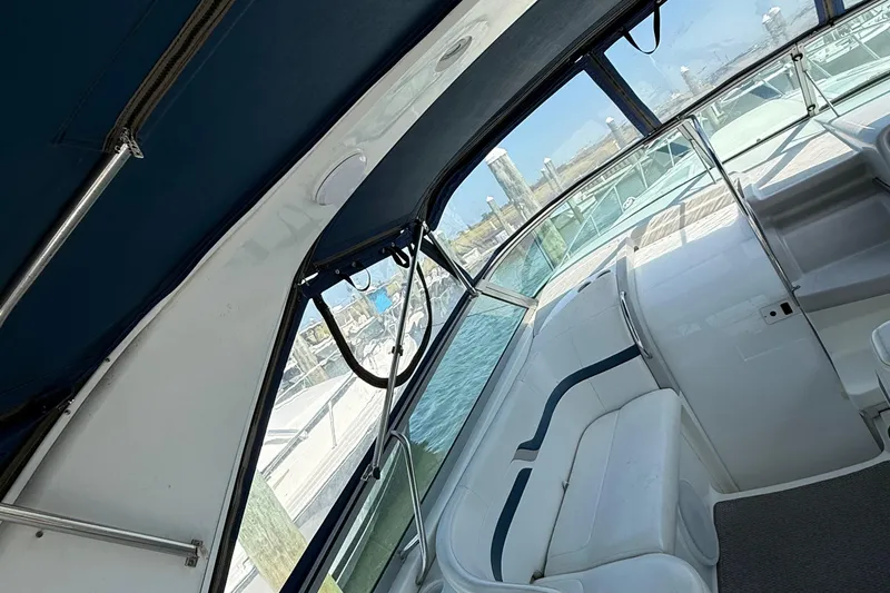 Slide: The Image of Interior view of a 1999 Formula 400 Super Sport boat with white seating and blue canopy. - 10