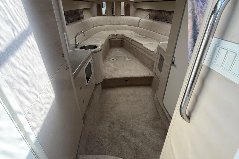 Slide: The Image of Interior of 1999 Formula 400 Super Sport boat with beige seating and kitchenette. - 24