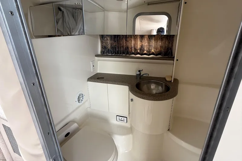 Slide: The Image of 1999 Formula 400 Super Sport boat bathroom with sink, toilet, and mirror. - 26