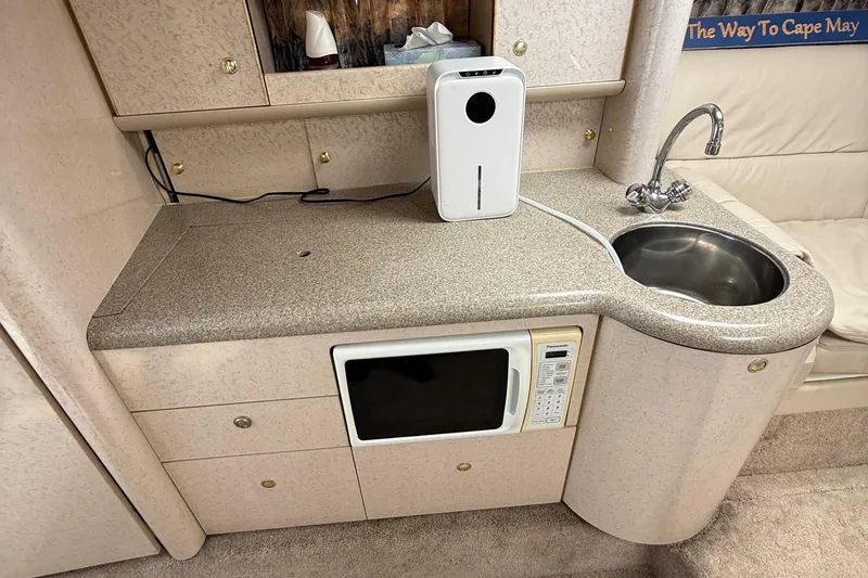Slide: The Image of 1999 Formula 400 Super Sport boat interior with kitchenette, sink, and microwave. - 29