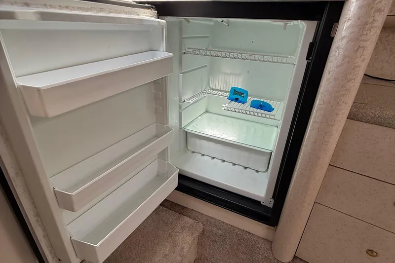 Slide: The Image of Open refrigerator inside a 1999 Formula 400 Super Sport boat, showing empty shelves. - 36