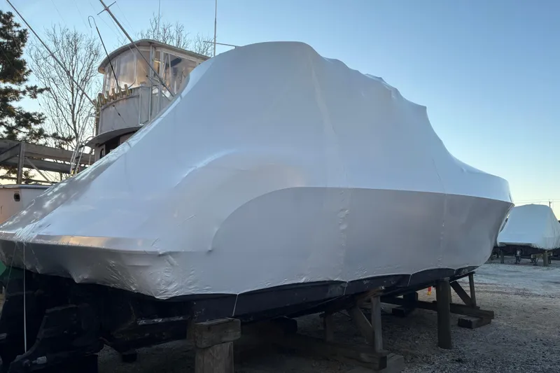 Slide: The Image of 1999 Formula 400 Super Sport boat covered in protective wrap, stored outdoors. - 58