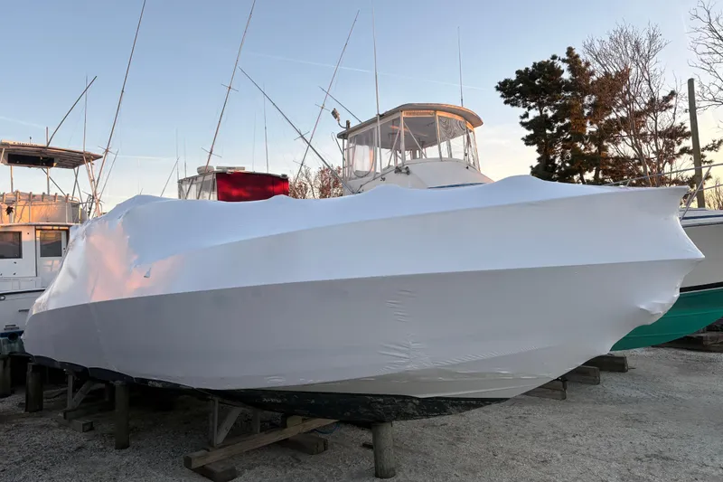 Slide: The Image of 1999 Formula 400 Super Sport boat covered in white tarp, docked outdoors. - 59