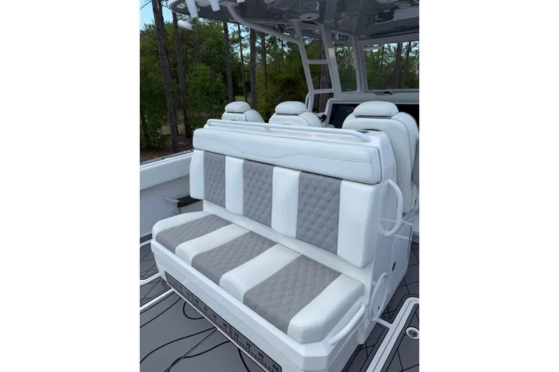 Slide: The Image of Luxury seating on 2022 Invincible 40 Catamaran, featuring white and gray quilted upholstery. - 6