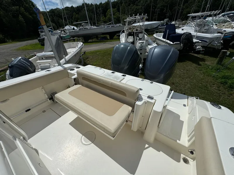 Slide: The Image of 2013 Cobia 296 Center Console boat with dual engines and seating, docked outdoors. - 11