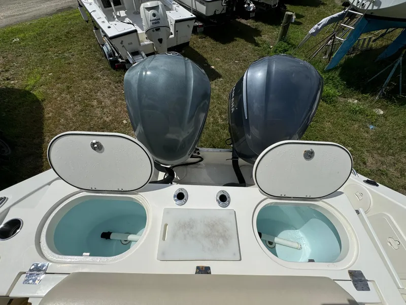 Slide: The Image of 2013 Cobia 296 Center Console boat with dual engines and open storage compartments. - 15