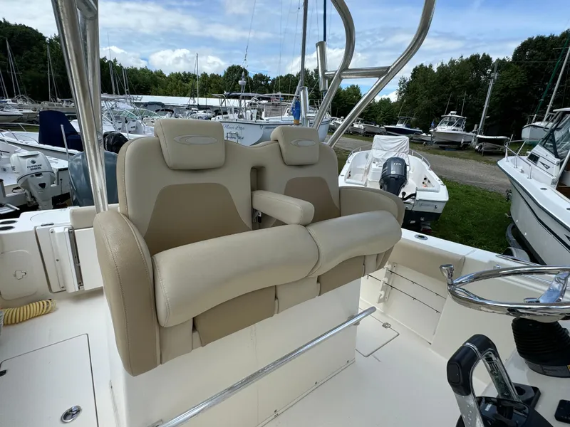 Slide: The Image of 2013 Cobia 296 Center Console boat with beige seating and steering wheel. - 27