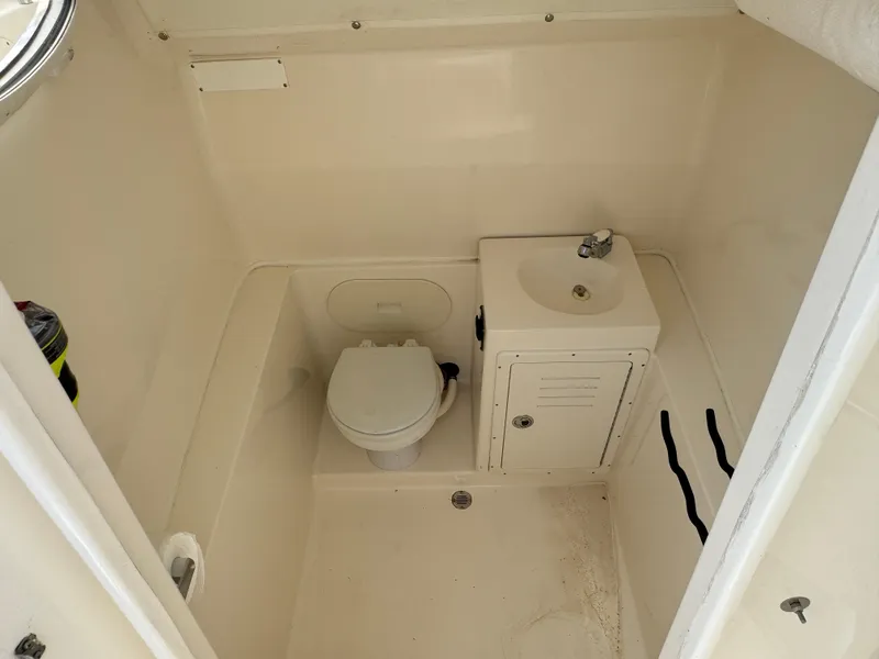 Slide: The Image of 2013 Cobia 296 Center Console boat interior with toilet and sink. - 38