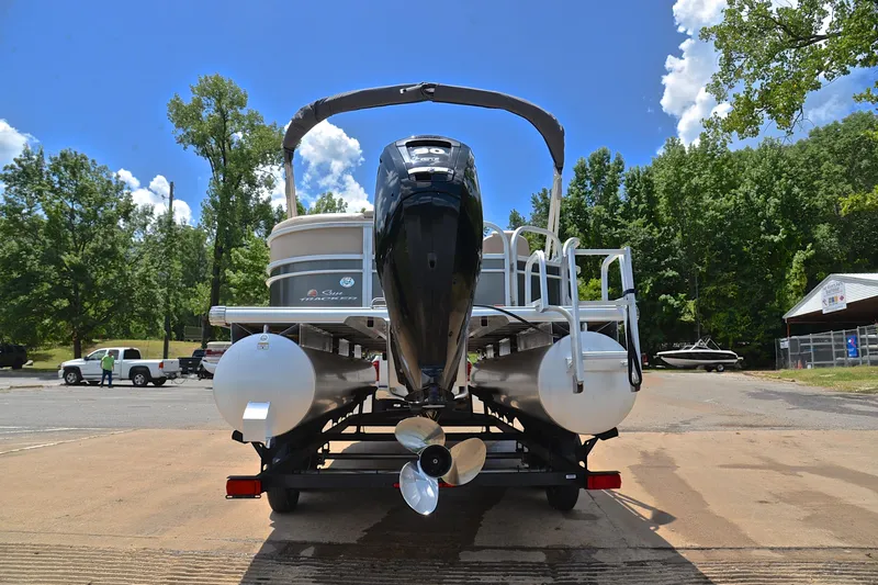 Slide: The Image of 2018 Sun Tracker Party Barge 20 pontoon boat on trailer, surrounded by trees and clear sky. - 12