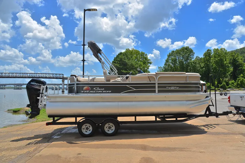 Slide: The Image of 2018 Sun Tracker Party Barge 20 pontoon boat on trailer by a lake. - 14