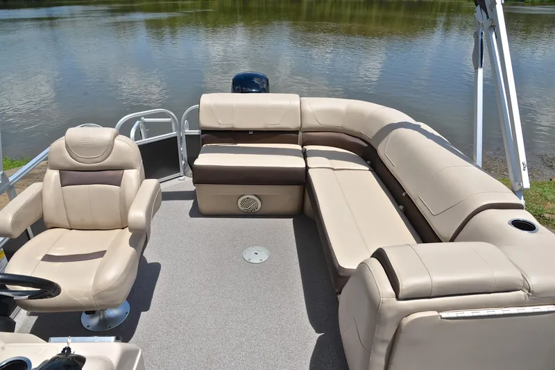 Slide: The Image of 2018 Sun Tracker Party Barge 20 with beige seating, docked by a serene lake. - 22