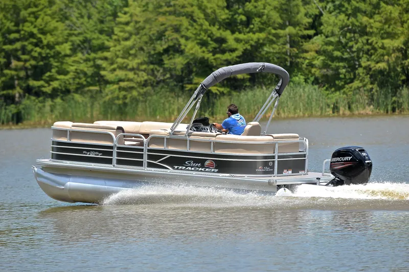 Slide: The Image of 2018 Sun Tracker Party Barge 20 pontoon boat cruising on a serene lake. - 4