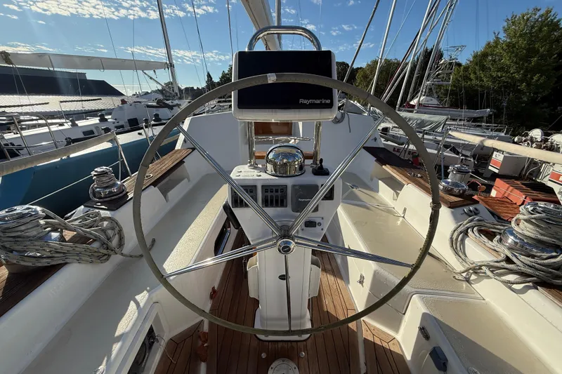 Slide: The Image of Steering wheel of a 2011 Tartan 4700 sailboat, docked with clear skies. - 25
