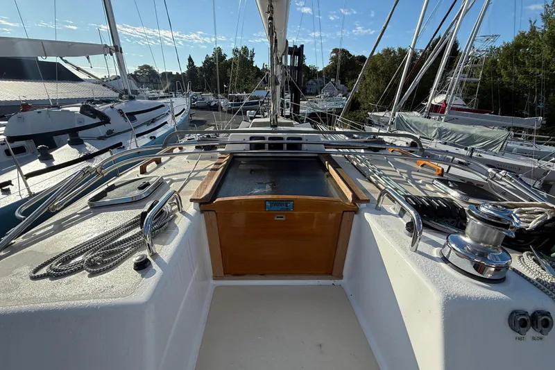 Slide: The Image of Sailboat deck view of 2011 Tartan 4700, featuring winches and rigging in a marina. - 32
