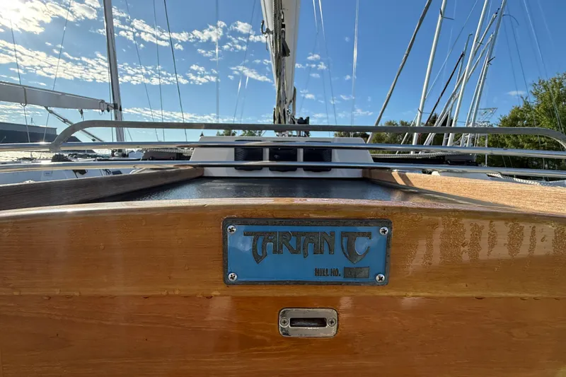 Slide: The Image of 2011 Tartan 4700 sailboat deck with nameplate under clear blue sky. - 33