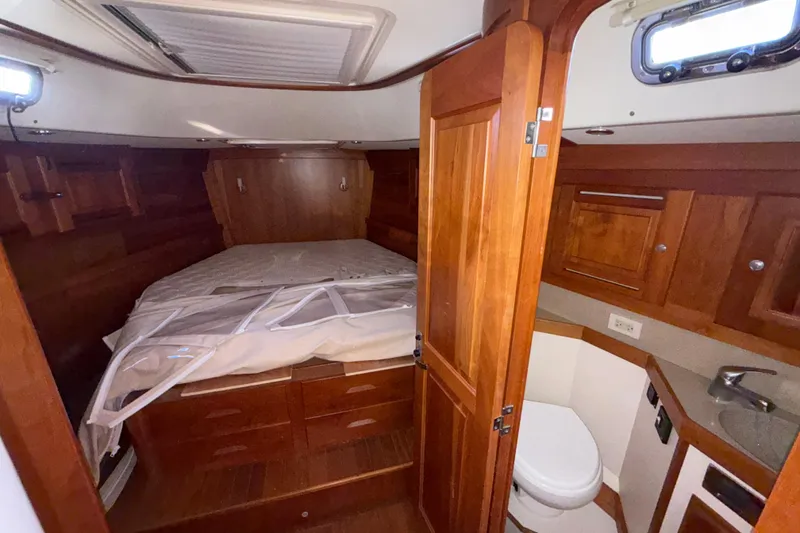 Slide: The Image of Cozy cabin interior of 2011 Tartan 4700 yacht with wooden furnishings and compact bathroom. - 43