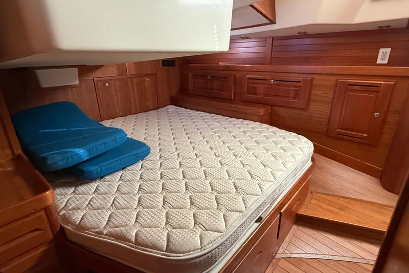 Slide: The Image of Cozy cabin interior of 2011 Tartan 4700 sailboat with wooden finish and mattress. - 44