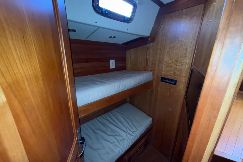 Slide: The Image of Wooden interior of 2011 Tartan 4700 sailboat with bunk beds and porthole. - 47