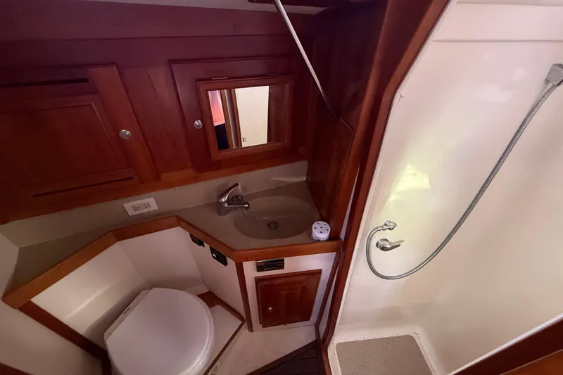 Slide: The Image of Compact bathroom in 2011 Tartan 4700 yacht with wood cabinetry and shower. - 54