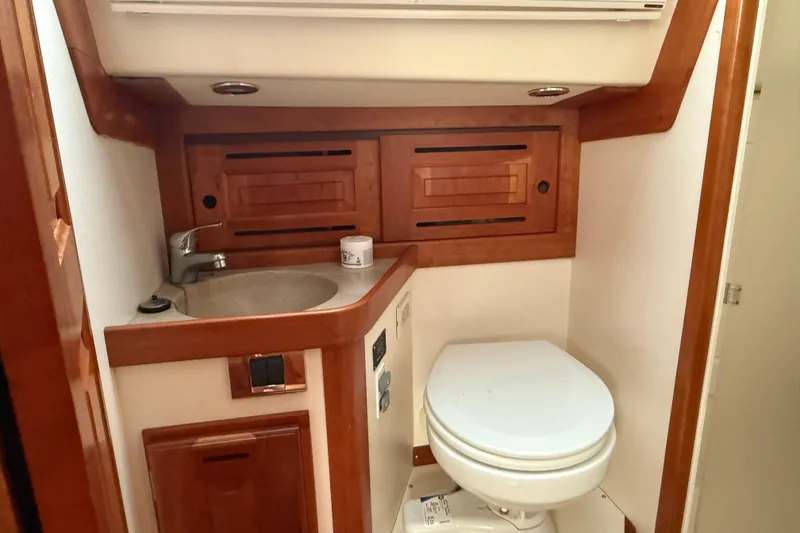 Slide: The Image of 2011 Tartan 4700 yacht bathroom with wooden cabinetry, sink, and toilet. - 55