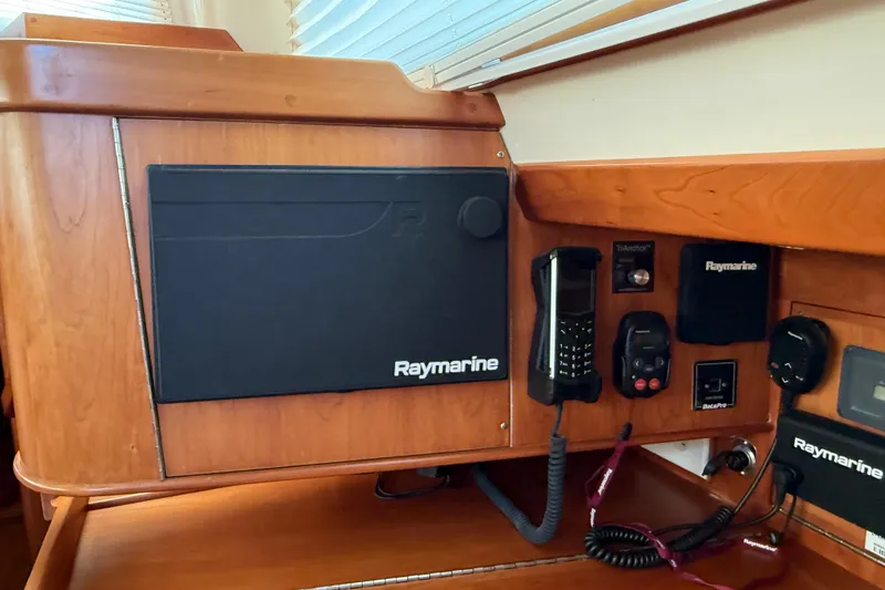 Slide: The Image of Navigation equipment on 2011 Tartan 4700 yacht, featuring Raymarine technology and wooden cabinetry. - 58