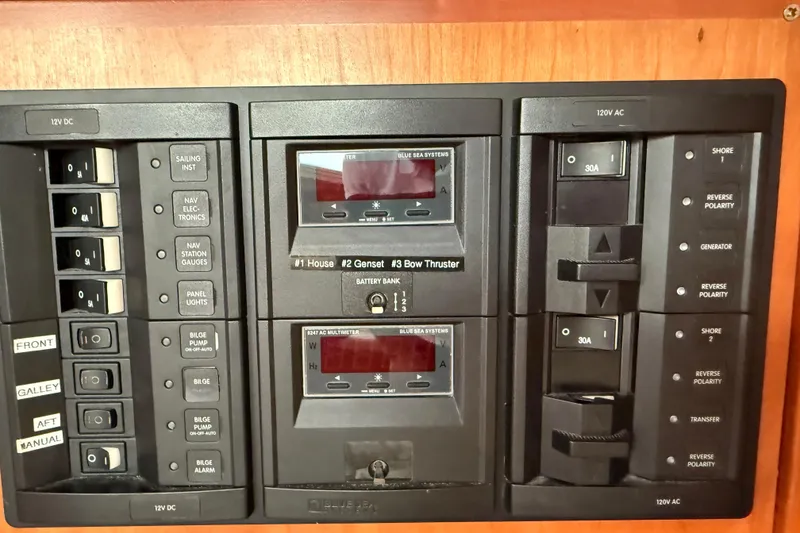 Slide: The Image of Electrical control panel on a 2011 Tartan 4700 yacht, featuring switches and meters. - 61