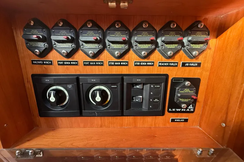 Slide: The Image of Control panel of a 2011 Tartan 4700 sailboat with labeled switches and circuit breakers. - 63