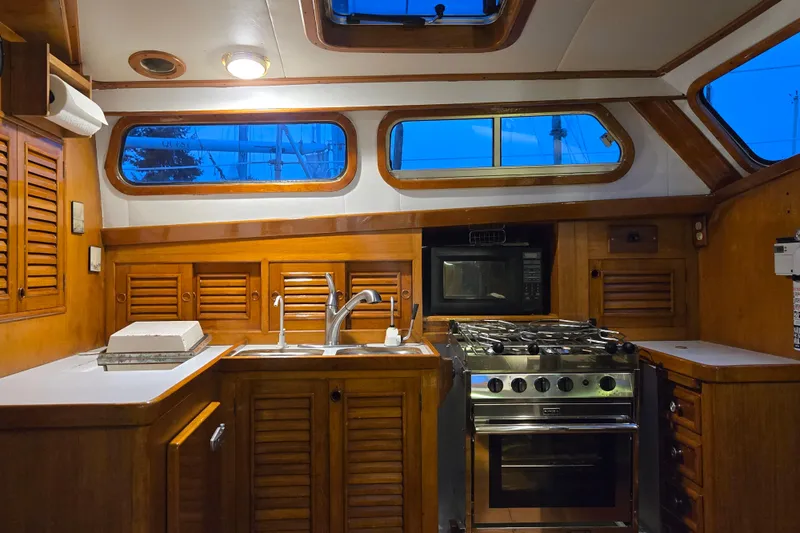Slide: The Image of Interior of 1981 Cheoy Lee 43 Pilot House yacht kitchen with wooden cabinetry and appliances. - 11