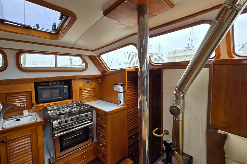 Slide: The Image of 1981 Cheoy Lee 43 Pilot House interior with kitchen, stove, and wooden cabinetry. - 12