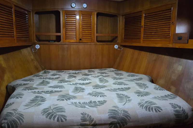 Slide: The Image of 1981 Cheoy Lee 43 Pilot House cabin with wooden interior and patterned bedding. - 18