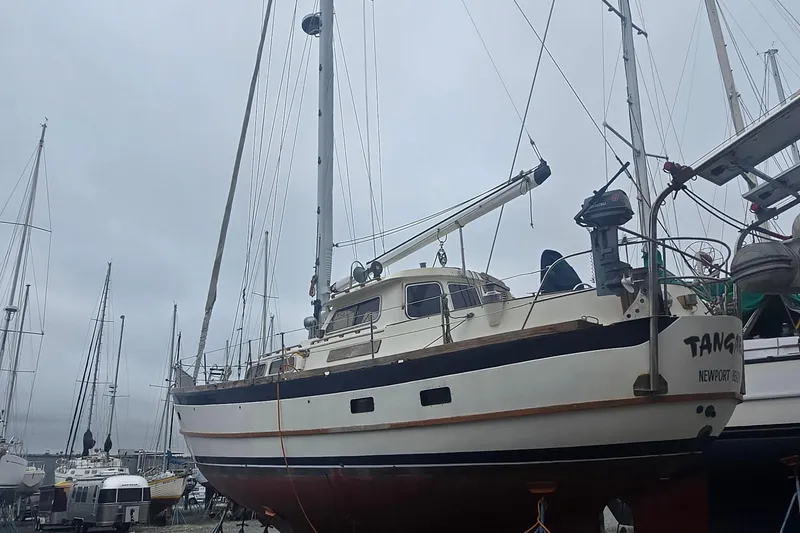 Slide: The Image of 1981 Cheoy Lee 43 Pilot House sailboat docked in a marina, overcast sky. - 2