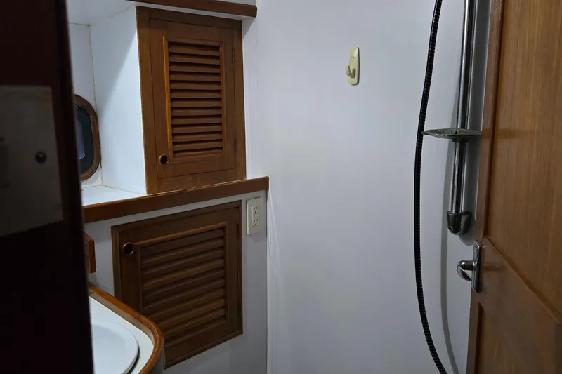 Slide: The Image of 1981 Cheoy Lee 43 Pilot House bathroom with wooden cabinets and shower. - 20