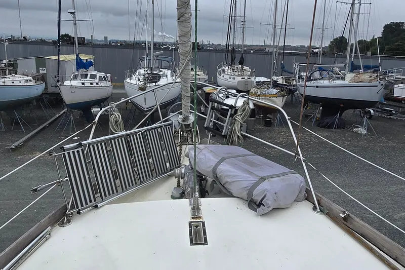 Slide: The Image of 1981 Cheoy Lee 43 Pilot House sailboat in a boatyard, surrounded by other vessels. - 4