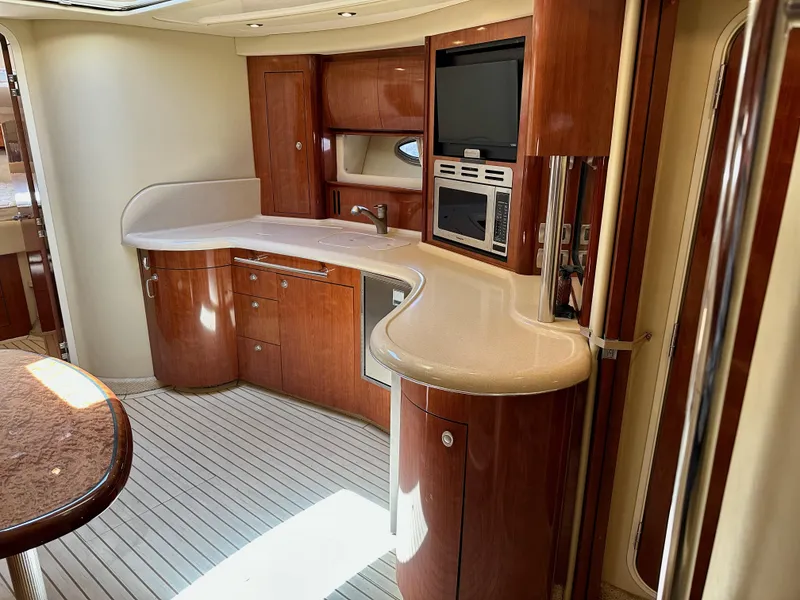 Slide: The Image of Luxurious 2004 Sea Ray 420 Sundancer yacht interior with elegant wood cabinetry and modern amenities. - 14