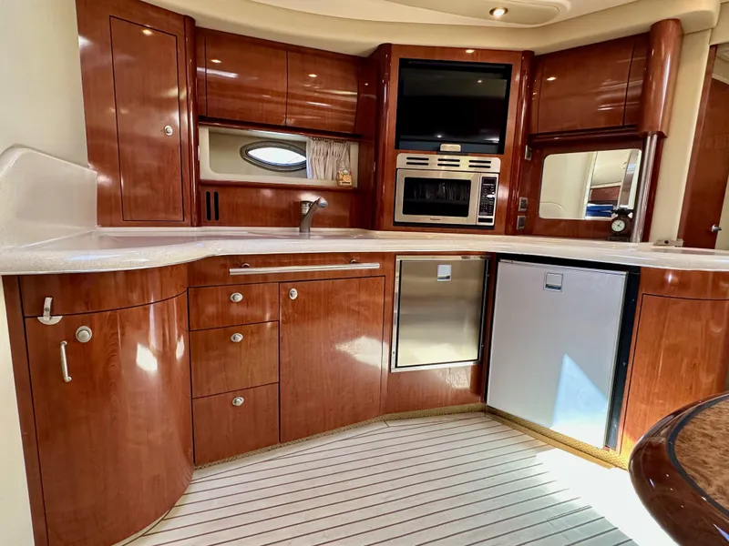 Slide: The Image of Luxurious 2004 Sea Ray 420 Sundancer yacht kitchen with wood cabinetry and modern appliances. - 15