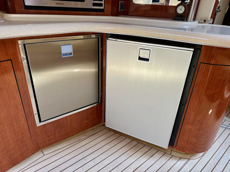 Slide: The Image of 2004 Sea Ray 420 Sundancer yacht kitchen with stainless steel appliances and wood cabinetry. - 16